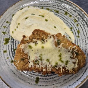 F1 - ȘNIȚEL DE PORC GRATINAT CU MOZZARELLA ȘI CARTOFI PIURE CU FETA (cotlet de porc, ou, faina, mozzarella, cartofi, lapte, unt, feta) - 350 gr.